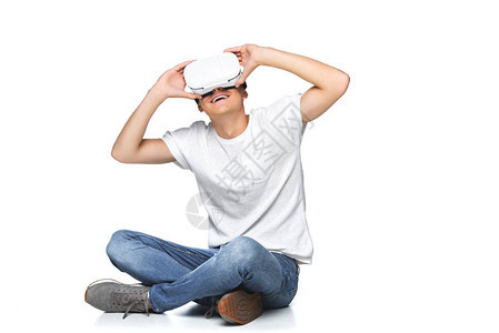 穿着白衬衫的笑着帅哥使用虚拟现实头盔图片