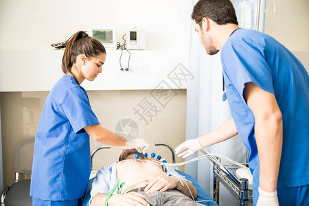 两名医生在急诊室将ECG电极放图片