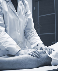 外科医生骨科医生检查中年男患者以确定受伤疼痛活动能力并诊断腿部膝关节半月板软骨脚踝和足背景图片
