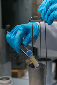 戴手套的手握住装有细胞悬液的试管进行冷冻保存含有干细胞悬浮液的氮库用于生物医学诊背景图片