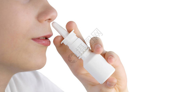男孩使用在白色上隔离的鼻涕喷雾图片