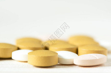 白色背景上的黄色白色和粉红色药片图片