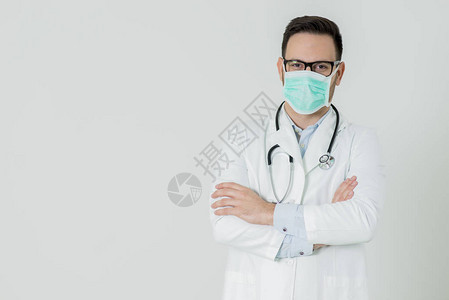 身穿白色医疗制服的英俊年轻医生的肖像和在白色背景下观图片