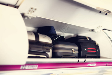 带手提箱的手提行李隔间在飞机上飞机顶架上的随身行李带有复制空图片