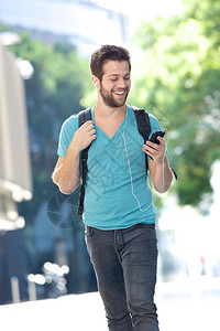 一个快乐的男学生带着手机在校园图片