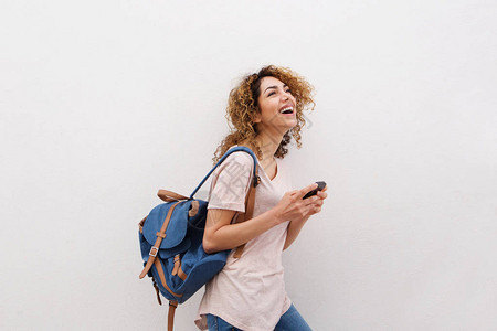 快乐的年轻女子用手提袋和手机行图片