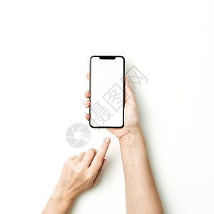 女人触摸着白色背景的智能手机新模型的空白屏幕平坦的躺下图片