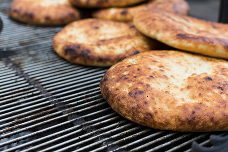 中东家庭在大型bbq烧烤炉上做了新鲜面包图片