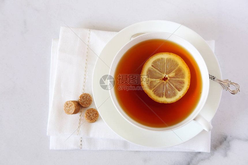 白骨瓷杯中含柠檬的黑茶光图片
