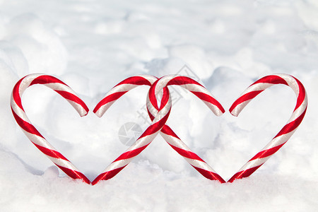 雪中的两颗心形糖果甘蔗图片