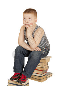 男孩坐在他头上的书本上图片