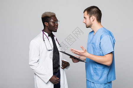 两位医生在灰色背景下会面并互相咨询高加索医生和美国黑人医生图片