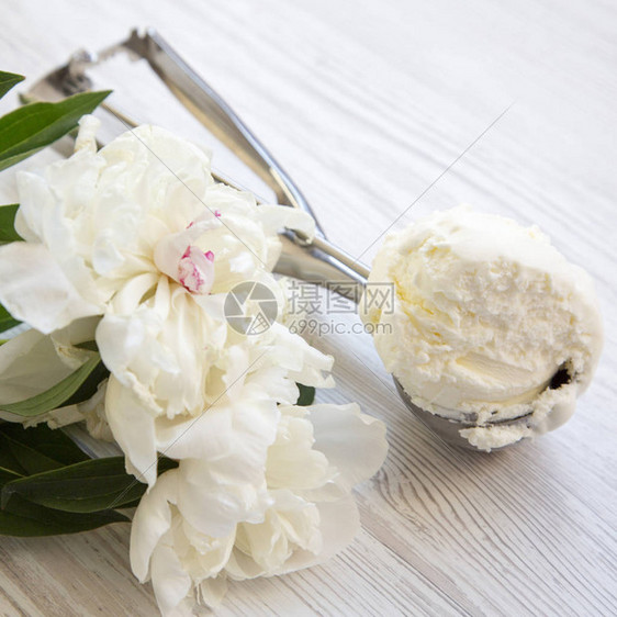 冰淇淋勺冰淇淋与白色牡丹花在白色木质表面上图片