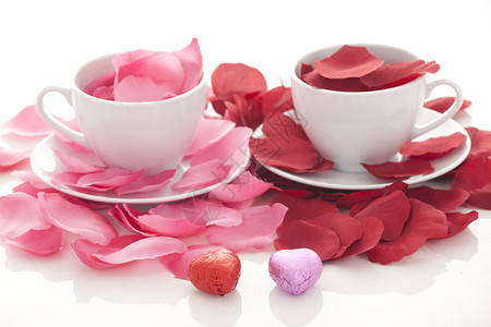 白色背景上的咖啡杯和玫瑰花瓣图片