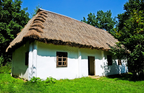 有白色墙壁和茅草屋顶的小屋图片