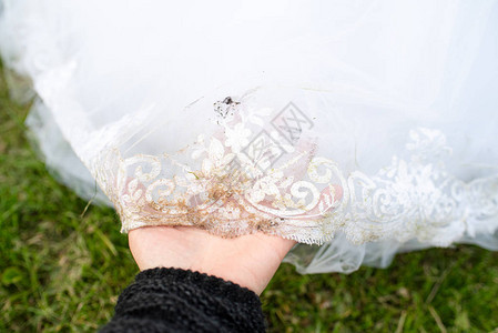 肮脏的婚纱新娘的白色礼服已经失去了它的外观干洗和图片
