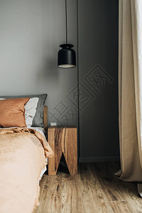 卧室配有床姜床罩枕头橡木床头柜设计师吊灯木地板灰色墙壁图片