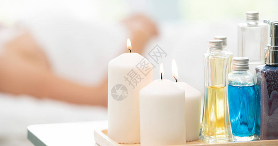 治疗套装包括按摩床上的芳香按摩油润肤露蜡烛和草药提取物背景图片