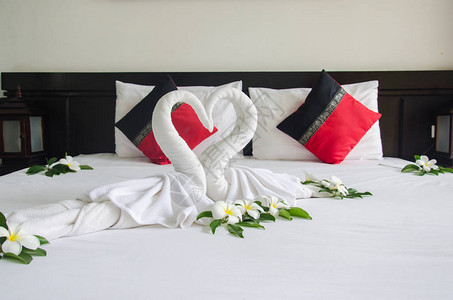床边有天鹅毛巾酒店房间对夫妇图片