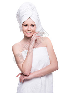美丽的年轻女子在洗完澡后穿着毛巾在白图片