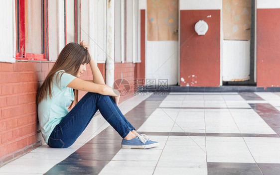 亚洲青少年担心在学校大厅坐着的欺图片
