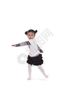 可爱小女孩的垂直形象在白色背景上跳舞时转弯图片