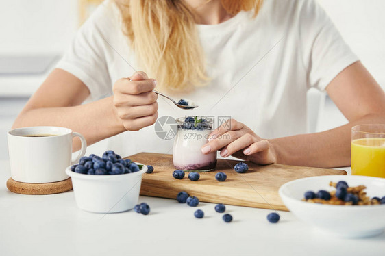 在桌顶用酸奶蓝莓咖啡杯和早餐果汁的酸奶图片