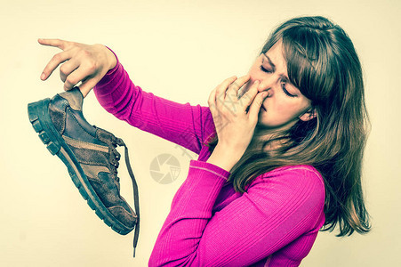 拿着脏臭鞋的女人难闻的气味概图片