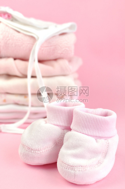 短靴和一堆粉红色的婴儿衣物图片