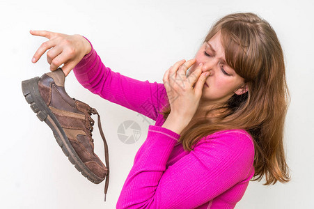 持有肮脏臭鞋子的妇女不愉图片