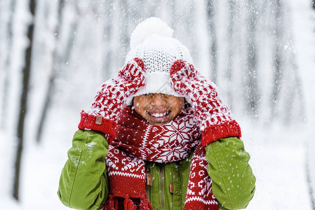 在冬季公园下雪时戴着毛帽的非洲小孩被图片
