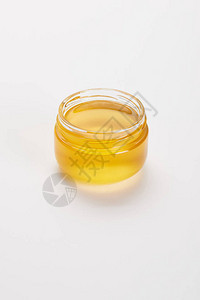 白色表面玻璃罐中甜蜜有机蜂蜜图片