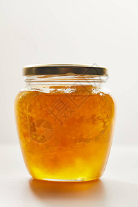 白色背景的玻璃罐中蜂蜜图片