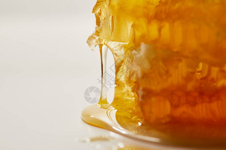 白色背景上甜蜂蜡和蜂蜜的近景图片
