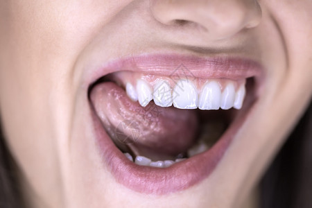 张开一个女人的笑容她把舌头按在嘴的右侧宏图片