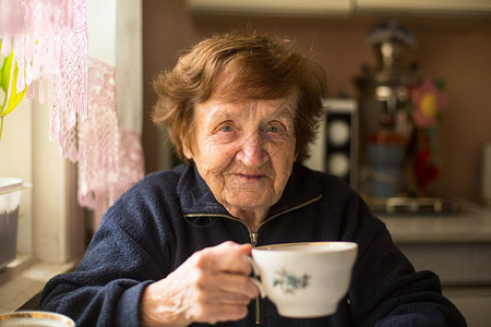 一位在家中喝茶的老年妇女图片