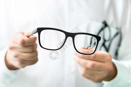 戴眼镜的光学医生显示新镜片的眼科医生穿白大衣图片