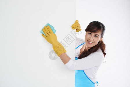 亚洲女人用湿布擦白墙图片