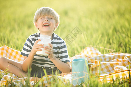 可爱的小孩在户外喝牛奶野餐图片