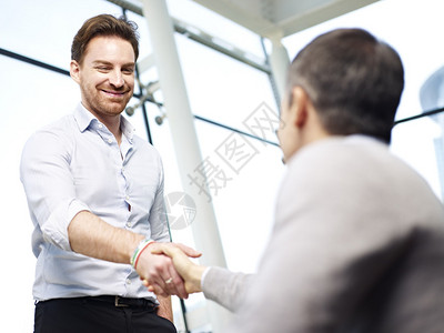 两位天主教商人通过在现代办公室握手互相打招呼图片