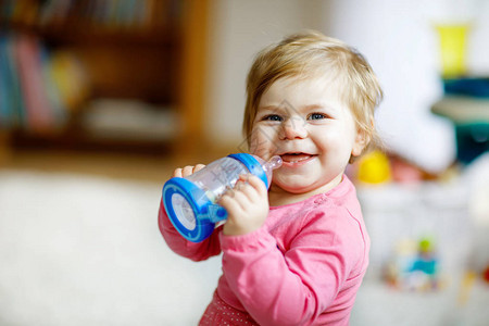 可爱的女婴拿着奶瓶喝配方奶或水婴儿的第一餐健康婴儿和童图片