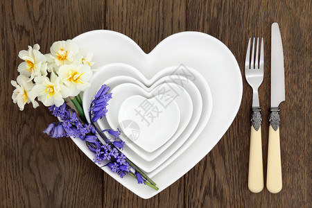 花桌布置着白色心形的瓷碗贝铃和自恋花朵图片