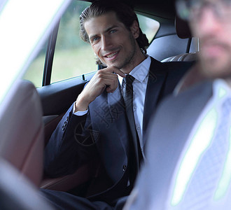 成功的商人坐在他的车里图片