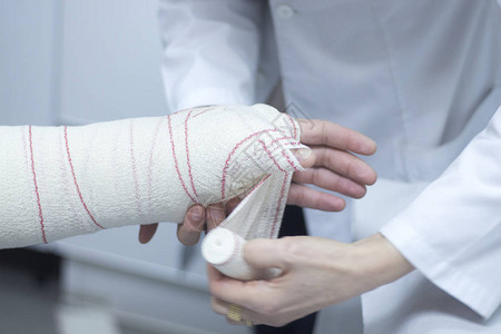 医生对病人前臂和手腕施用石膏和绷带图片