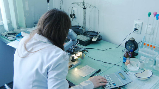 女医生科学家实验室女研究员通过显微镜进行检查图片