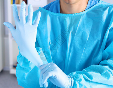 外科医生在近距离手术前戴上手套图片