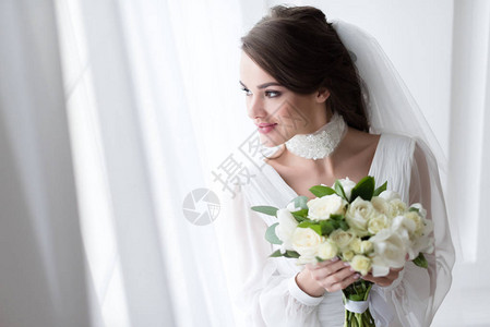 带着白色花束的婚纱和面纱图片
