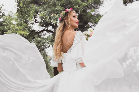 结婚礼服和花圈中的金发新娘的低角度视角在公图片