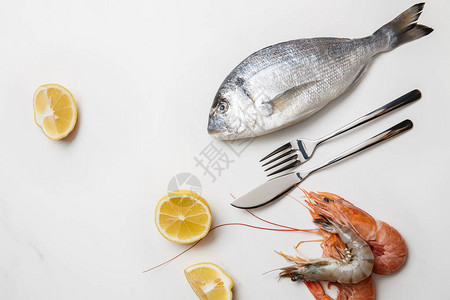 虾和鱼柠檬片和餐具用白色隔开图片