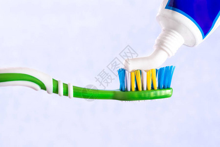 牙刷挤在牙刷膏蓝色背景上图片